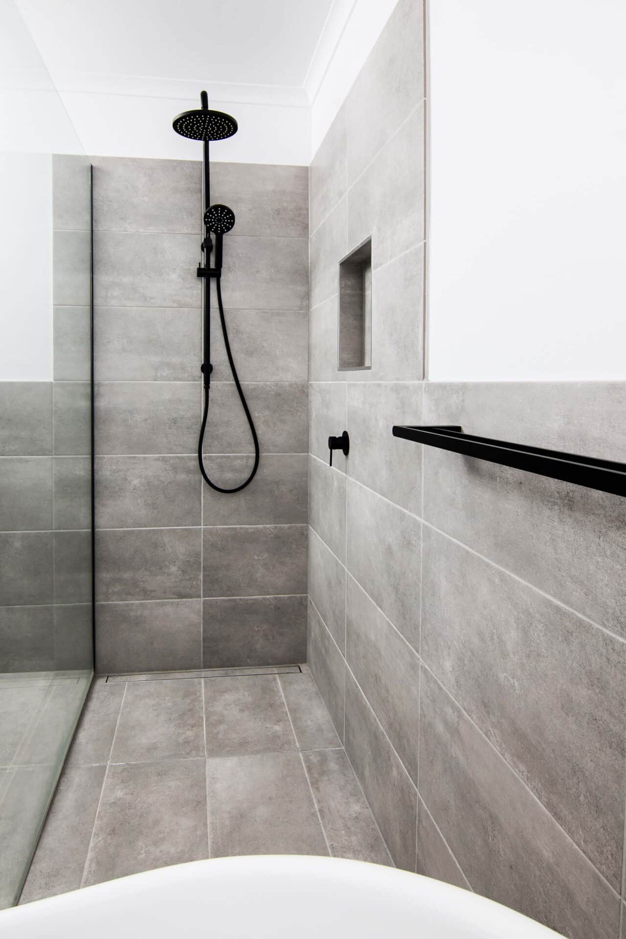 a shower with a black shower head