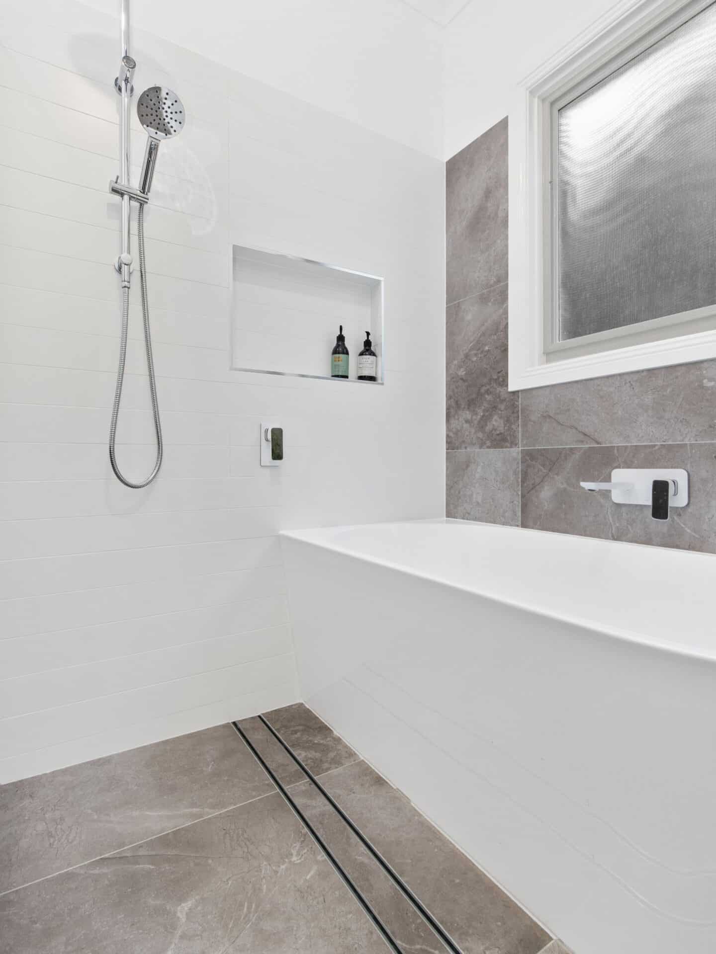 a white bathroom with a bathtub and shower