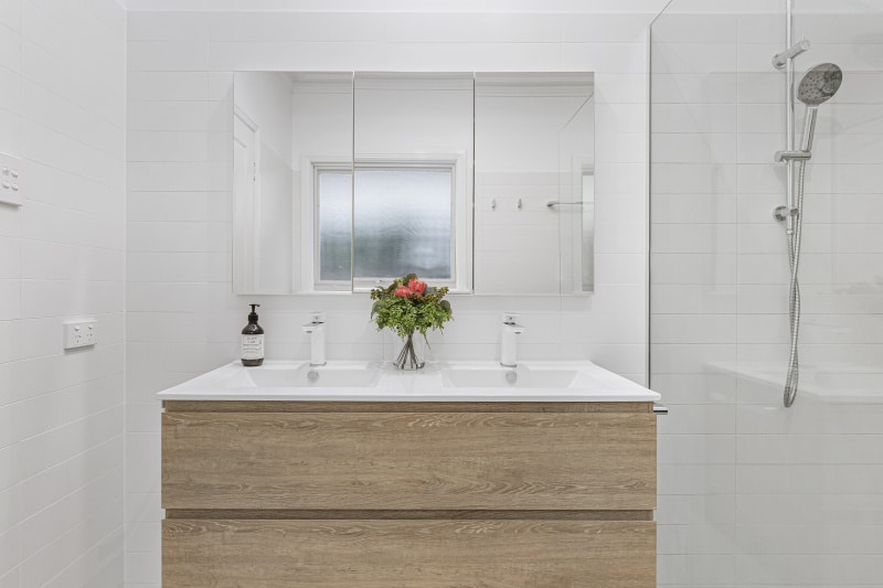 a white bathroom with a mirror and sink