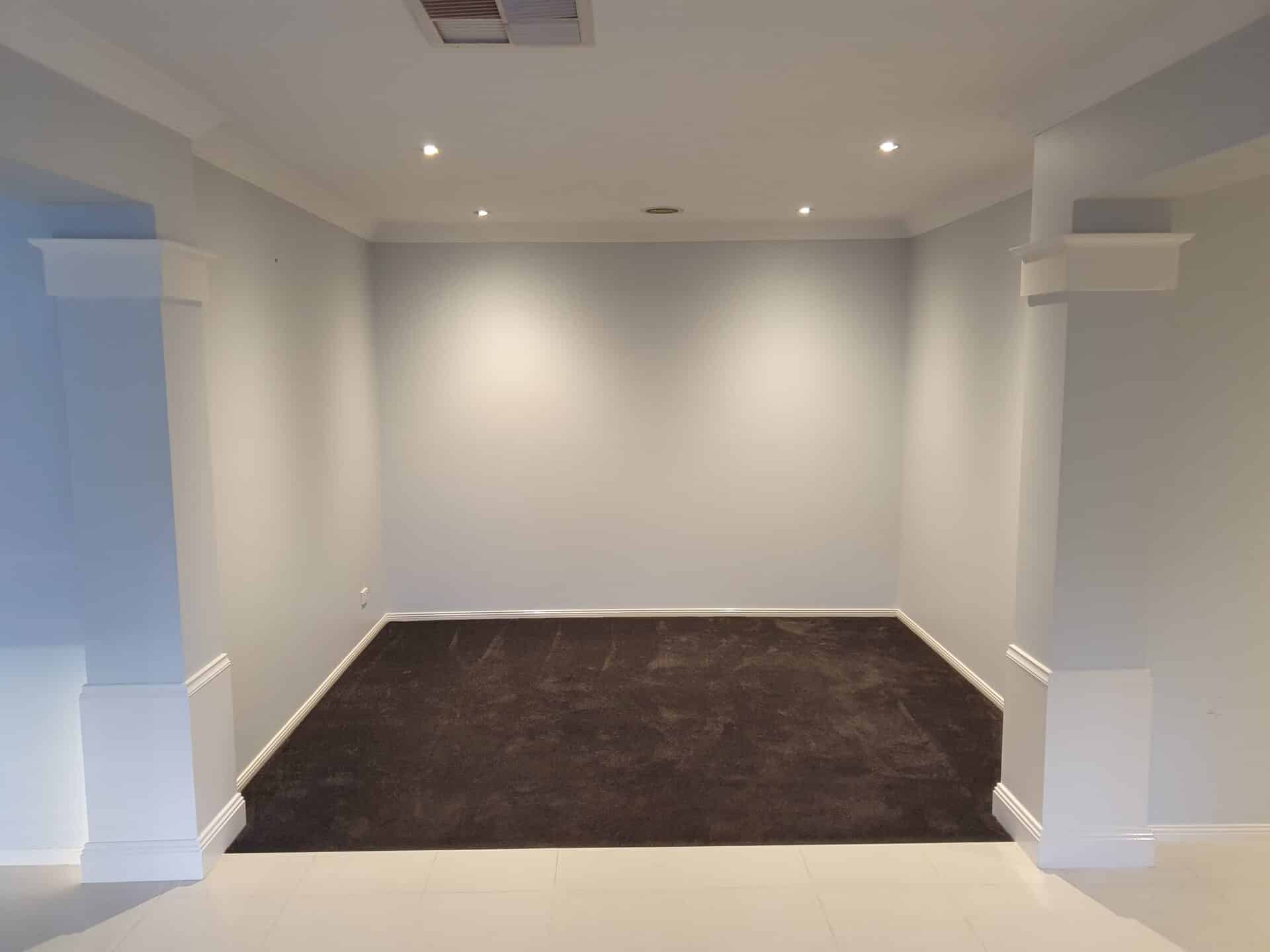 a wide white room with a carpet and a ceiling