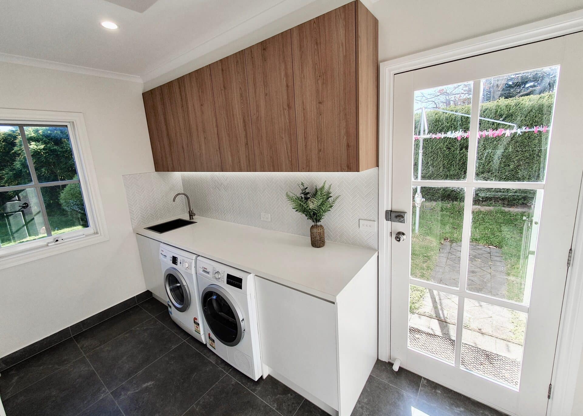 a laundry room with a white counter top and a wood cabinet
