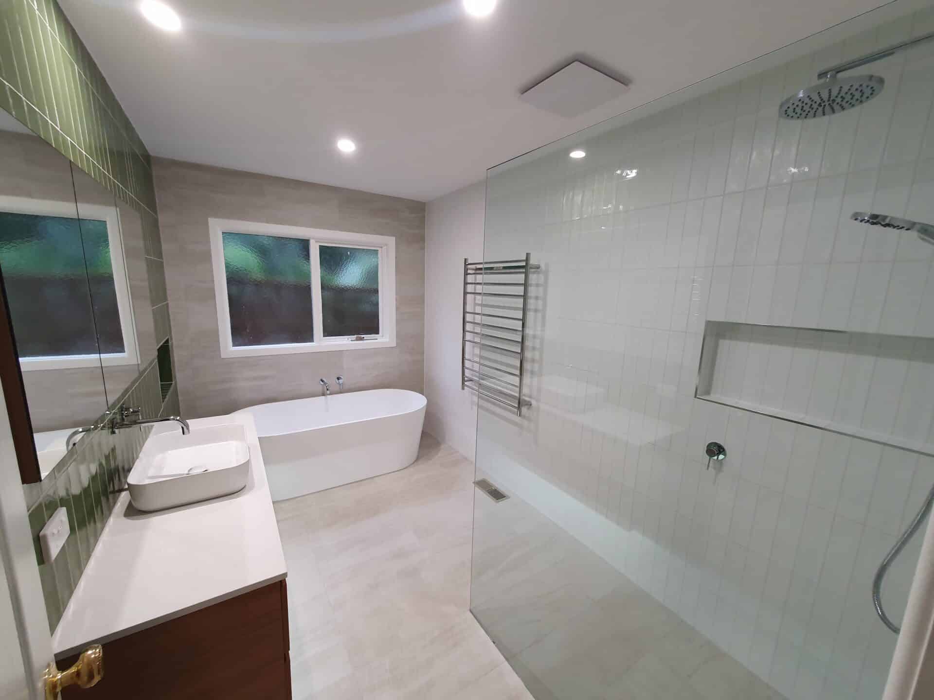 a modern bathroom with a tub, sink and shower with different floor and wall tiles