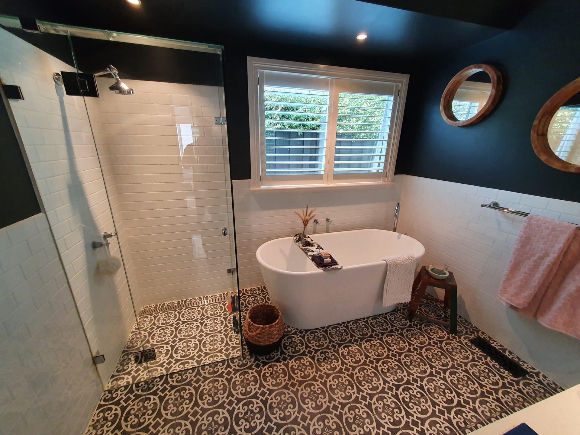 a gorgeous bathroom with a tub and shower and patterned floor tiles