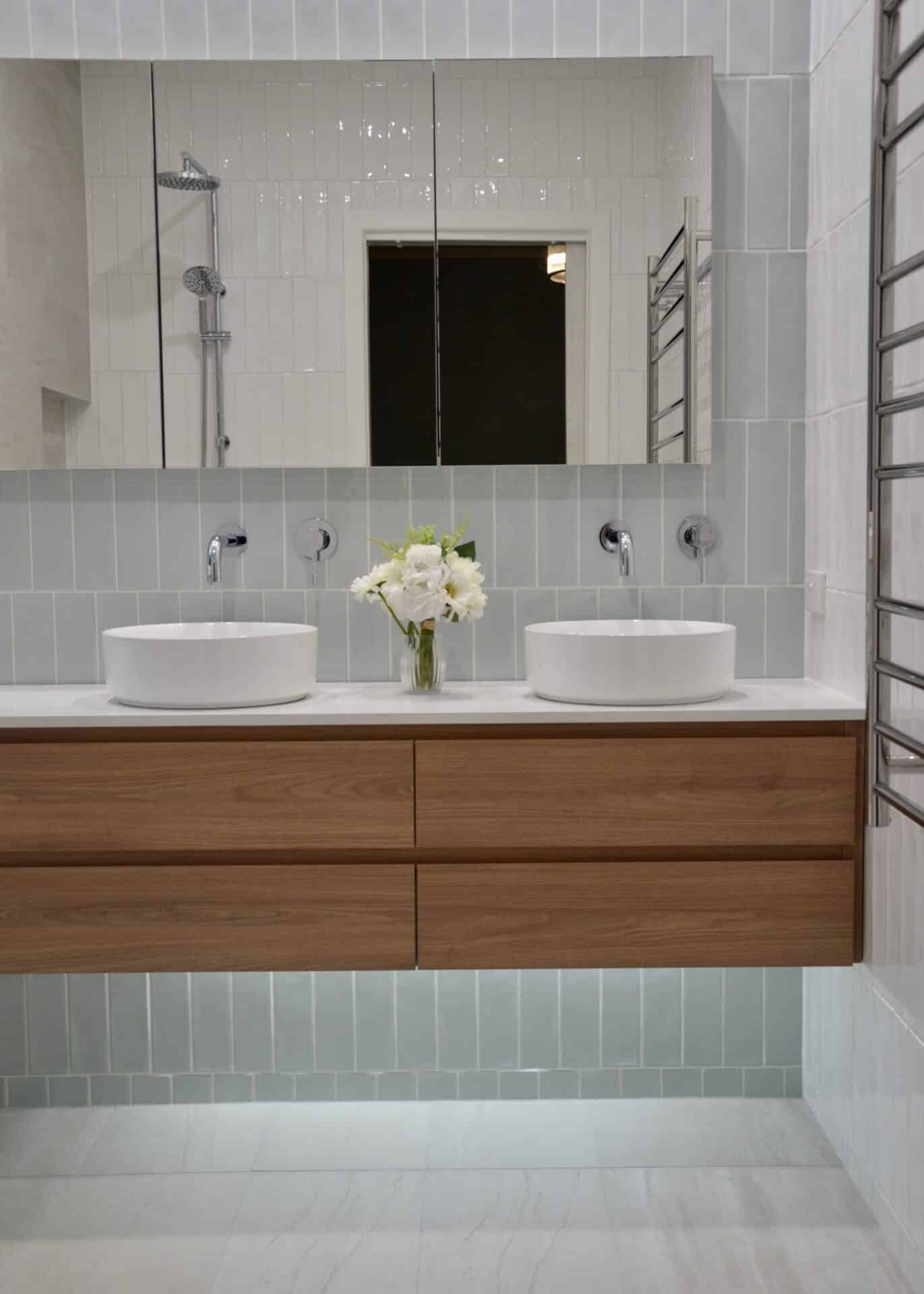 a bathroom with a mirror and sink above a wooden cabinet