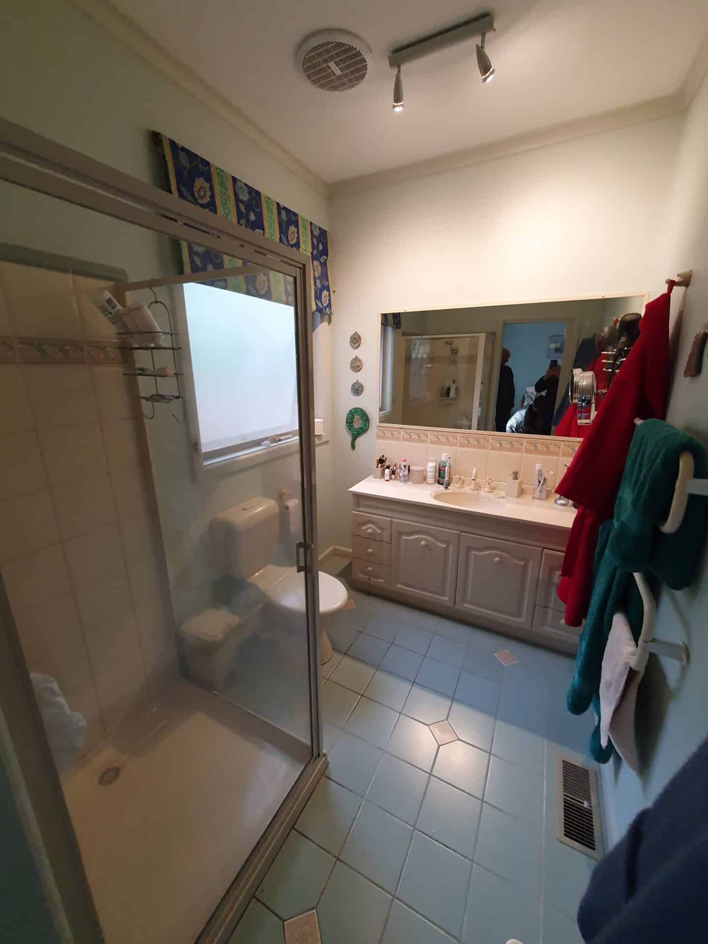 Ensuite Bathroom with a shower, toilet, with a large sink and mirror