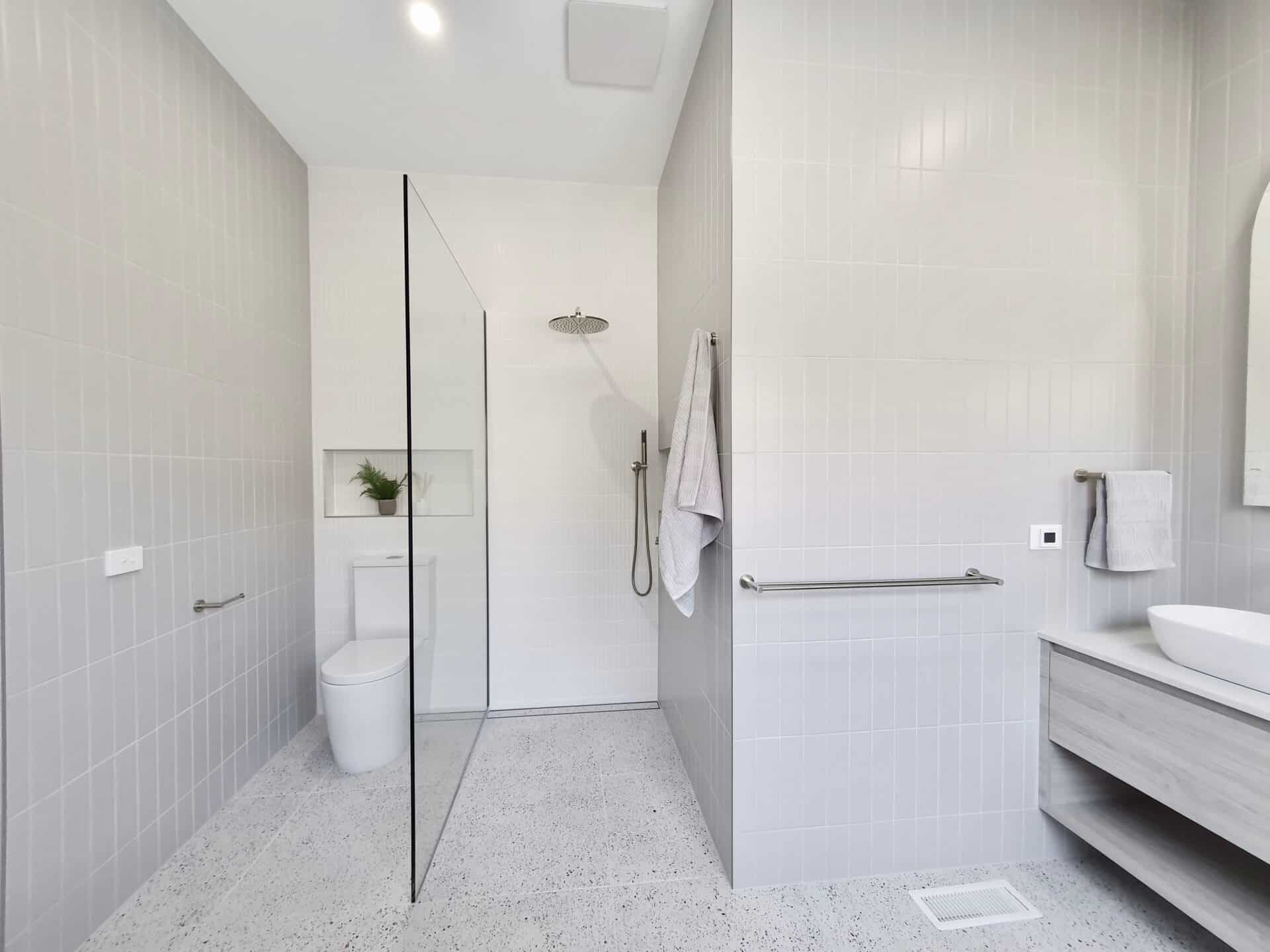 beautiful white bathroom with a shower, toilet and vanity