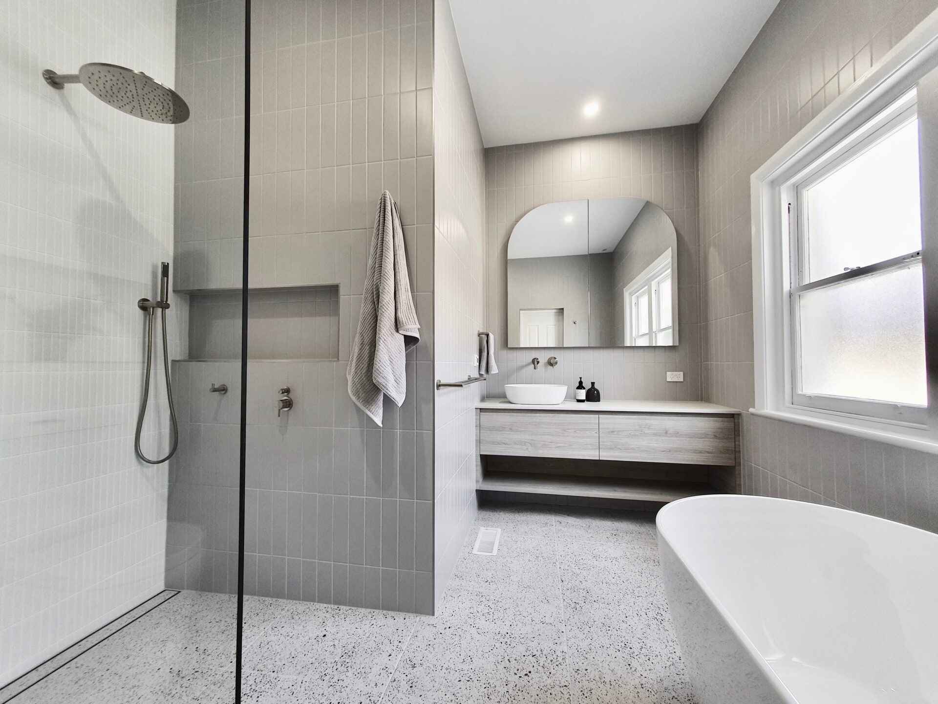modern bathroom with a shower, vanity, bath tub and a window