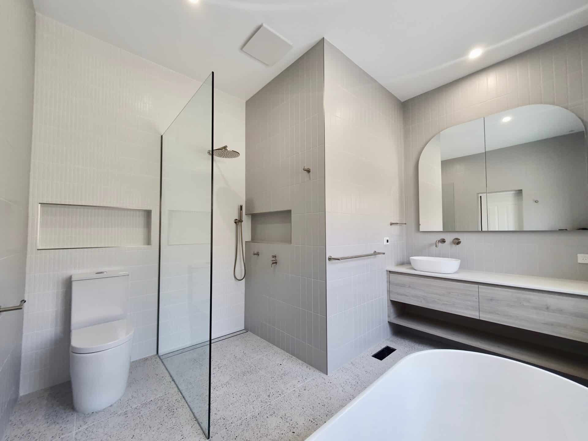 another view of a modern bathroom with a vanity, shower and bath tub