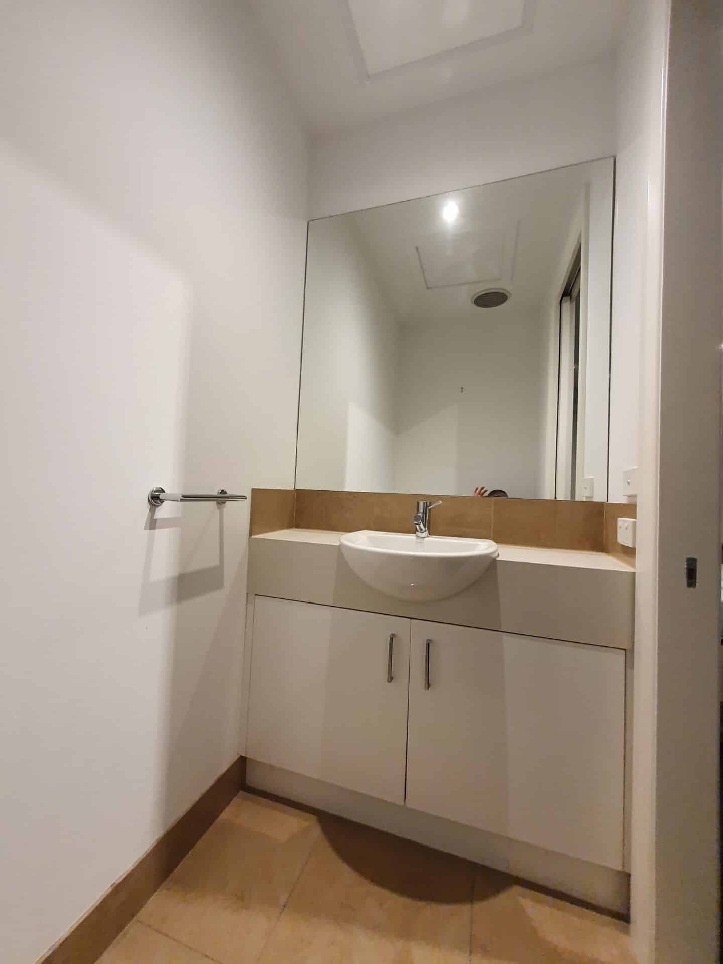 Modern powder room with a vanity and a large mirror.