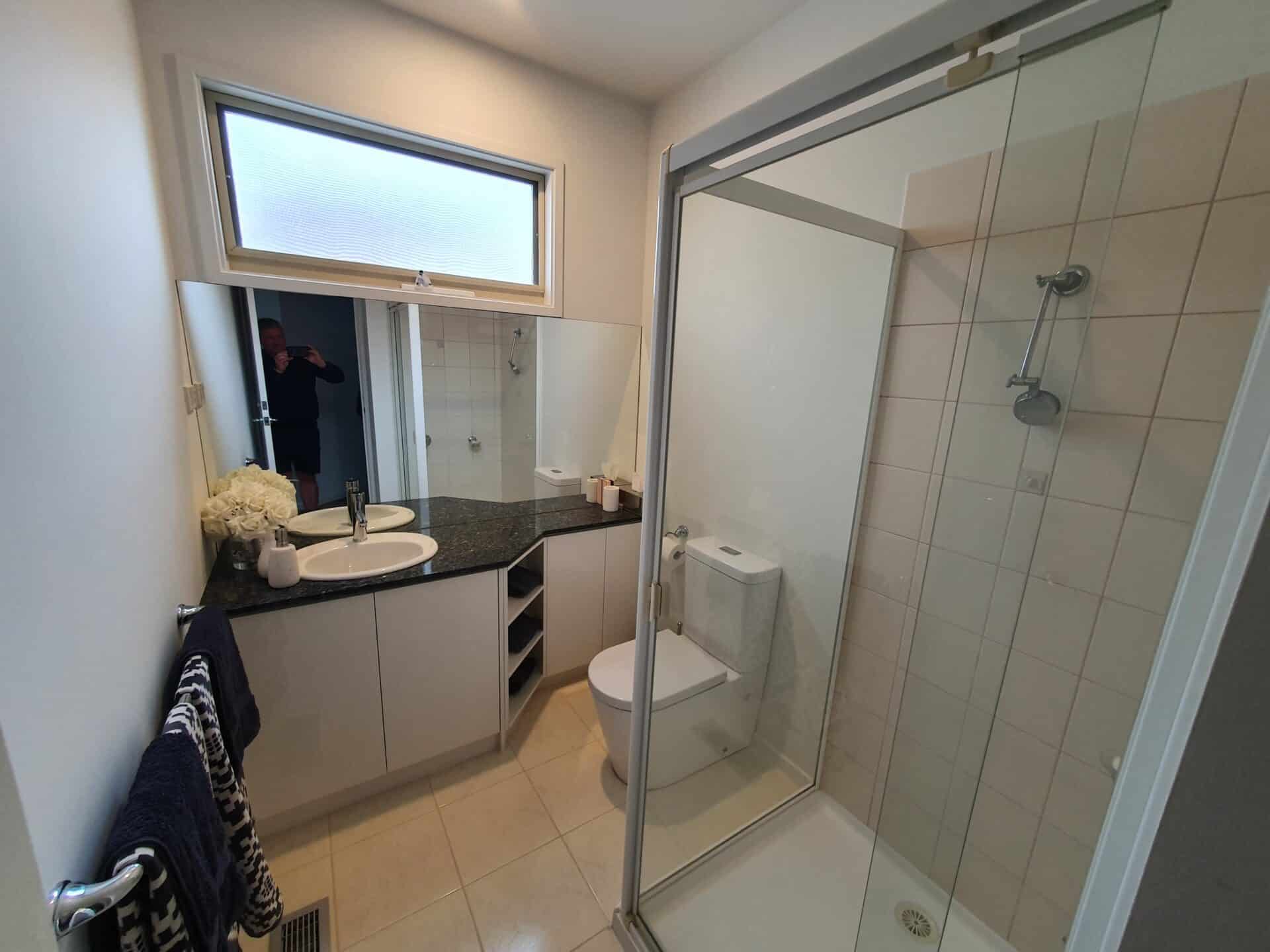 A bathroom with a walk in shower next to a sink.