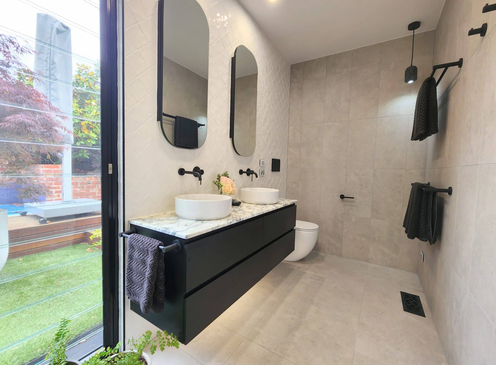 A bathroom with two sinks and a large window.