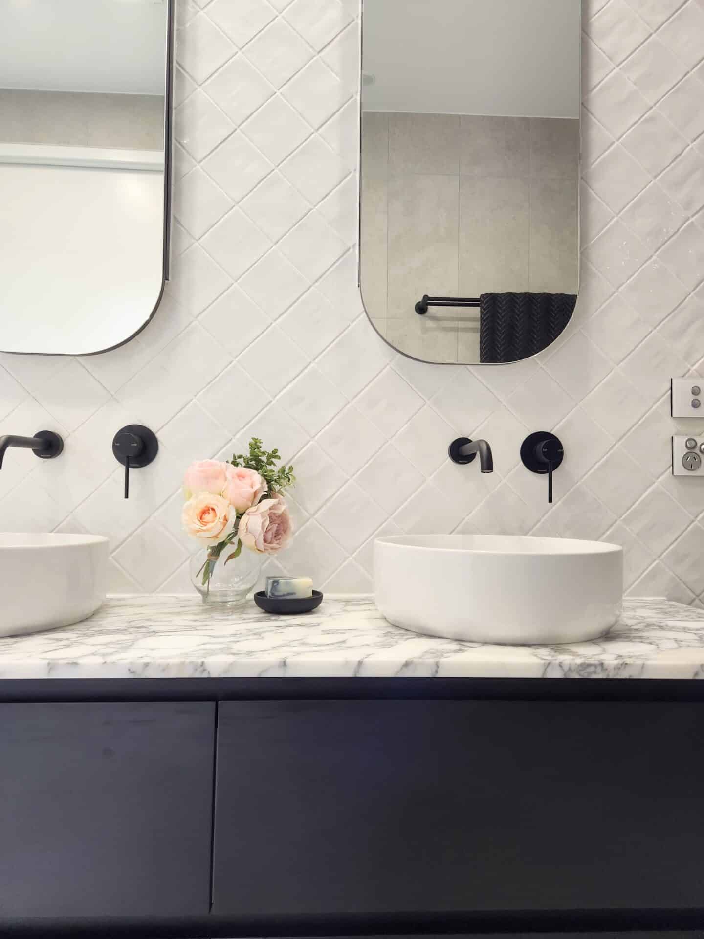A bathroom with a marble counter top and two sinks.