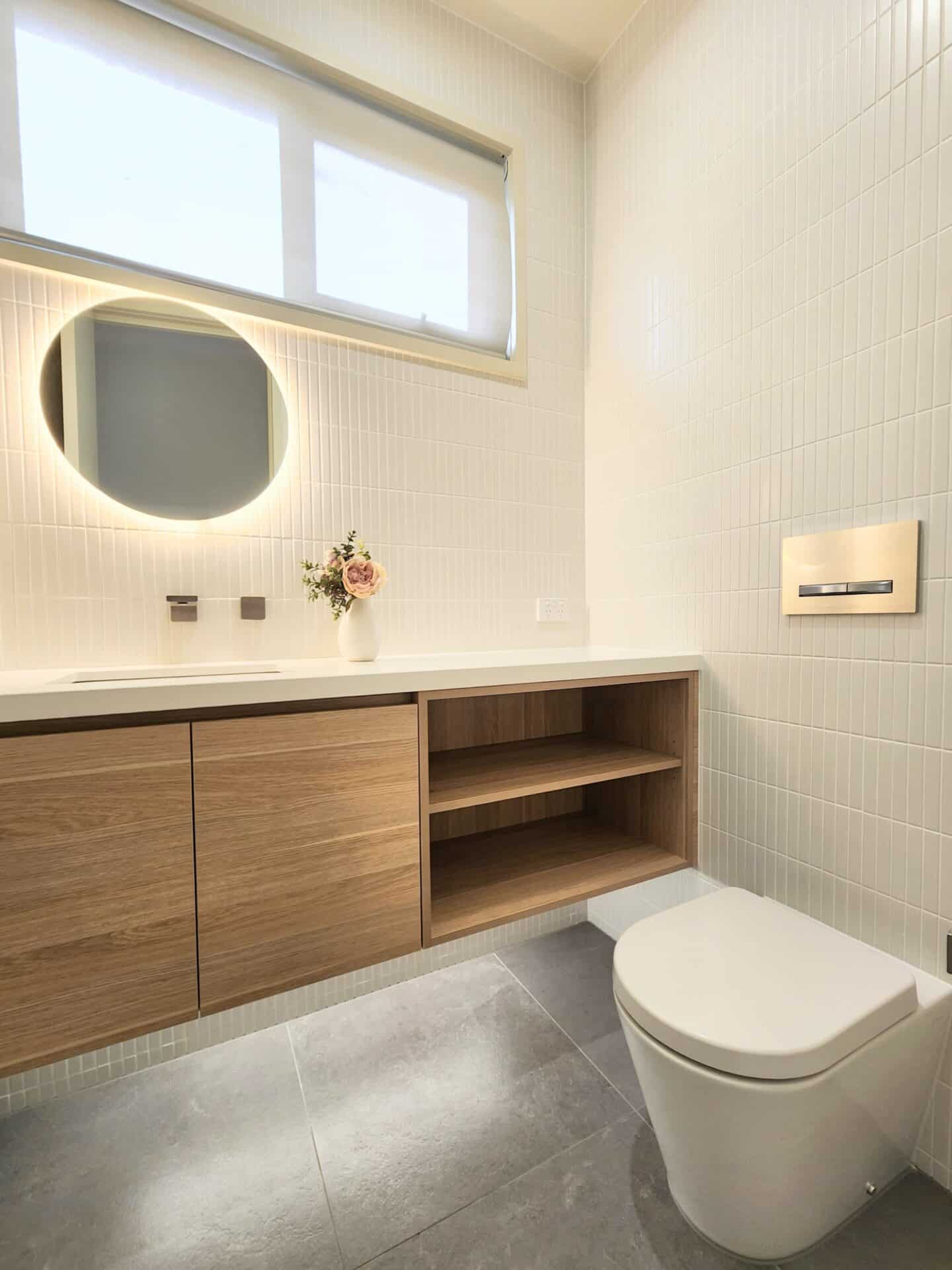 A white toilet sitting next to a powder room sink.