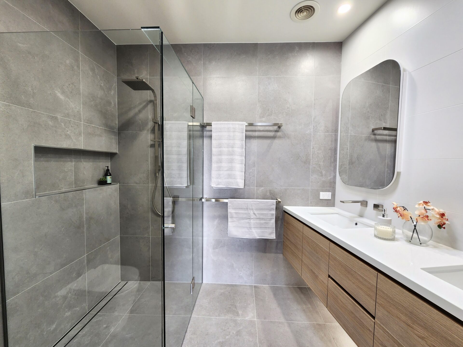 A powder room renovation project with glass showers and a vanity.