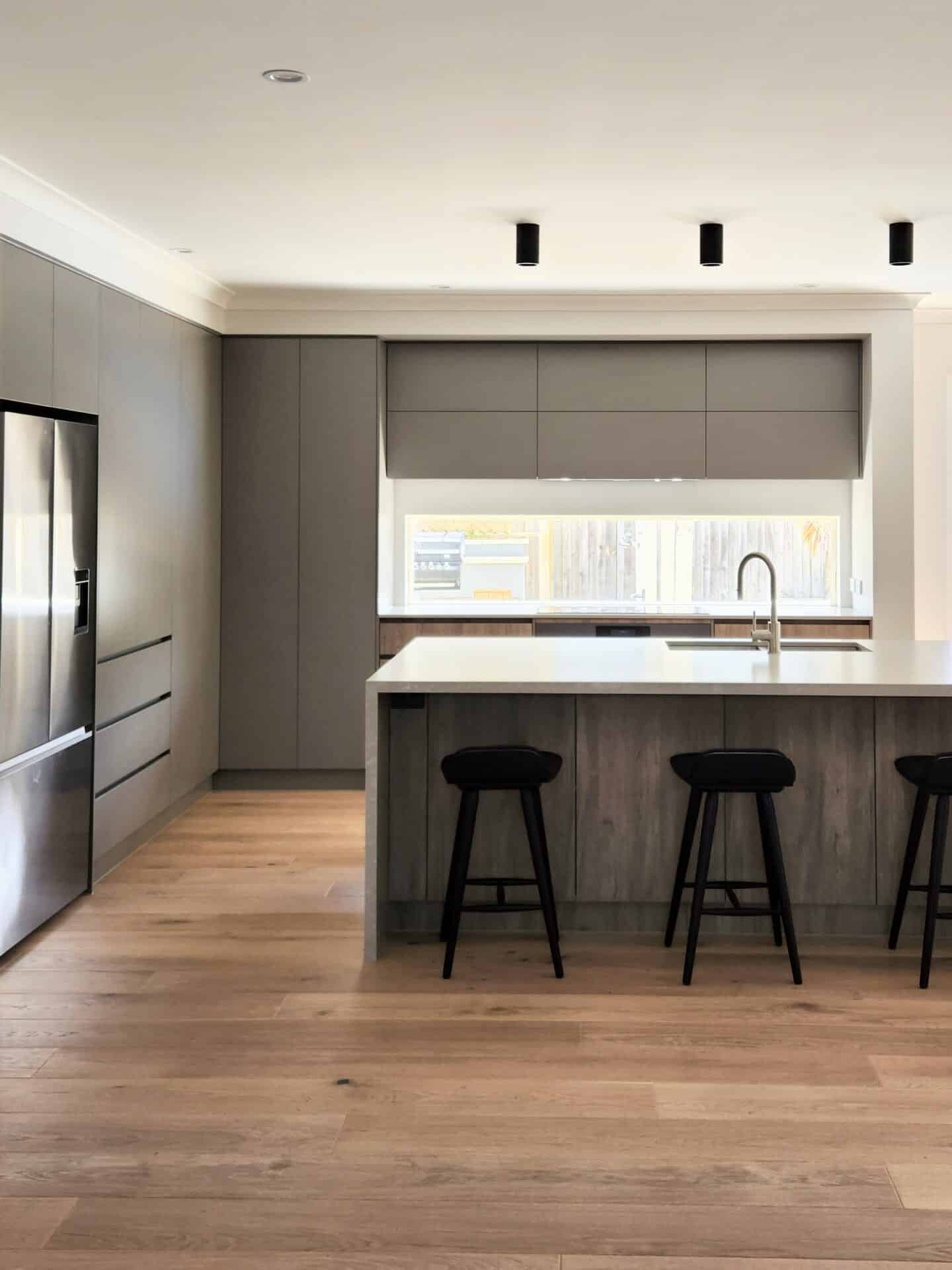 a kitchen renovation project with wooden floorings, a kitchen counter and sink, and a window.