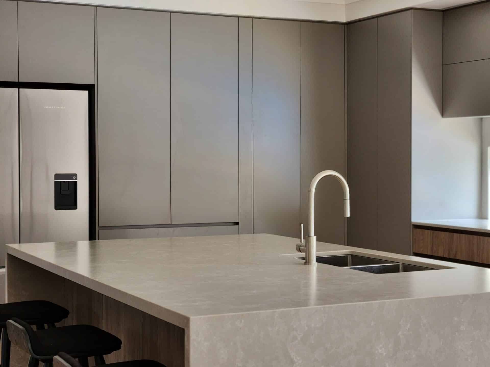 a beautiful kitchen counter with sink and a gray cabinets.