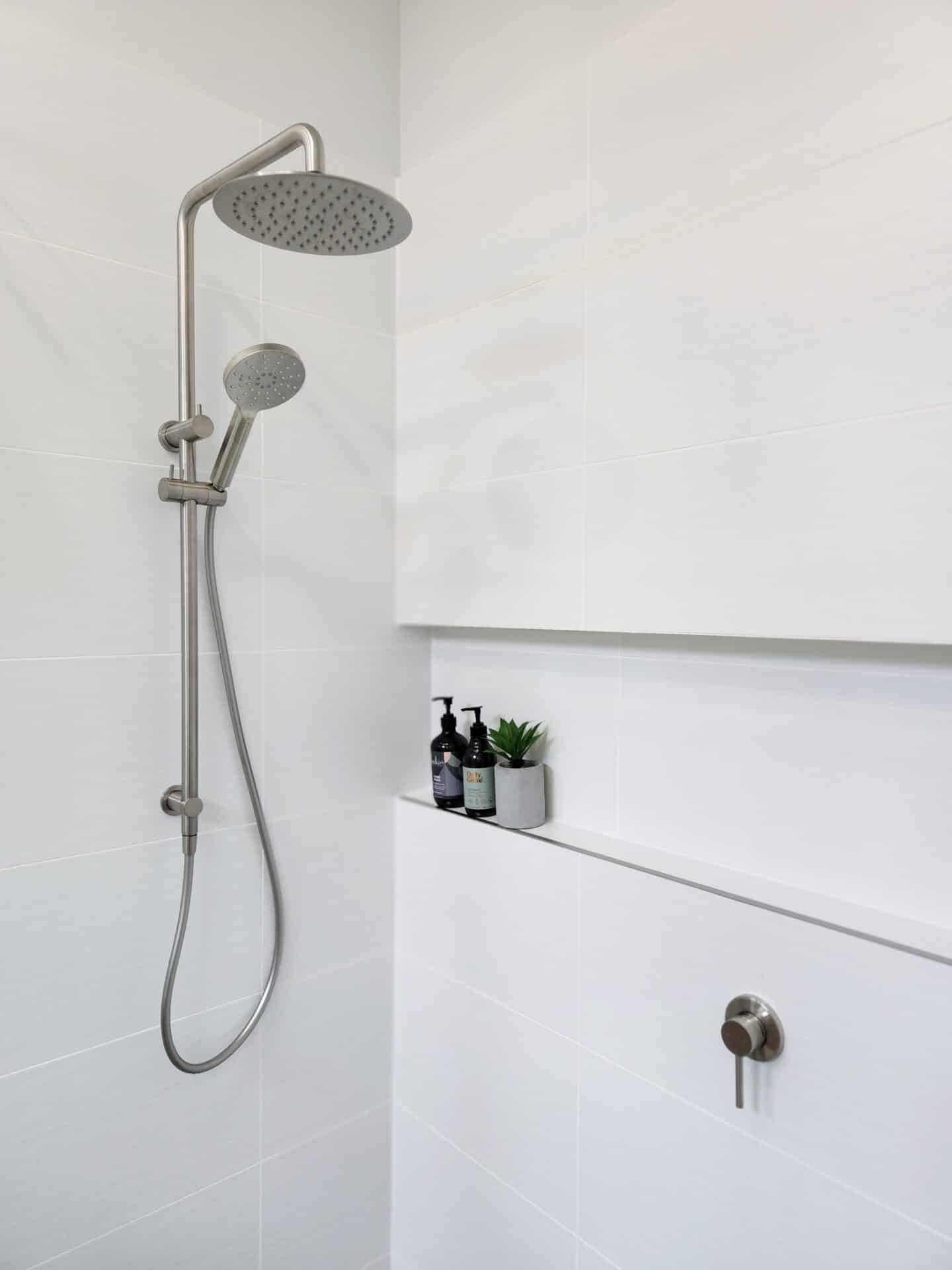 A shower head in a white bathroom