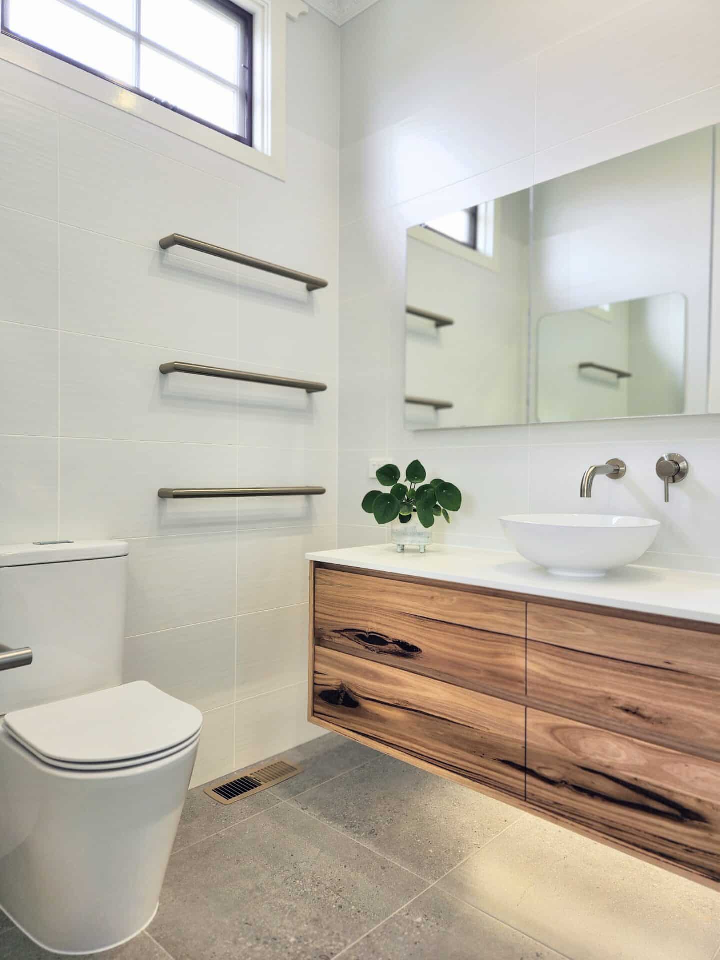 a white bathroom with a sink toilet and mirror.