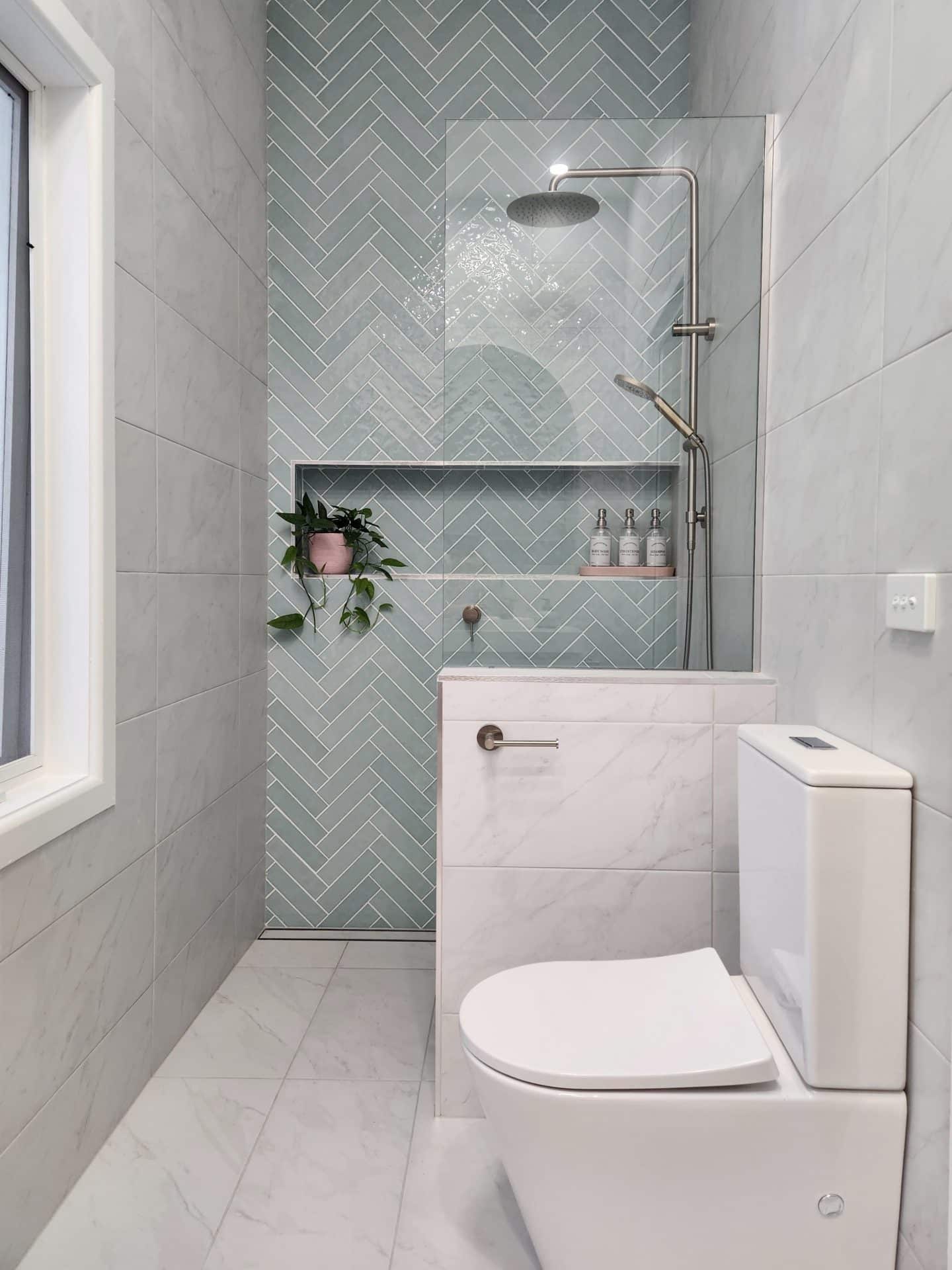 a small bathroom with tiled walls and a toilet.