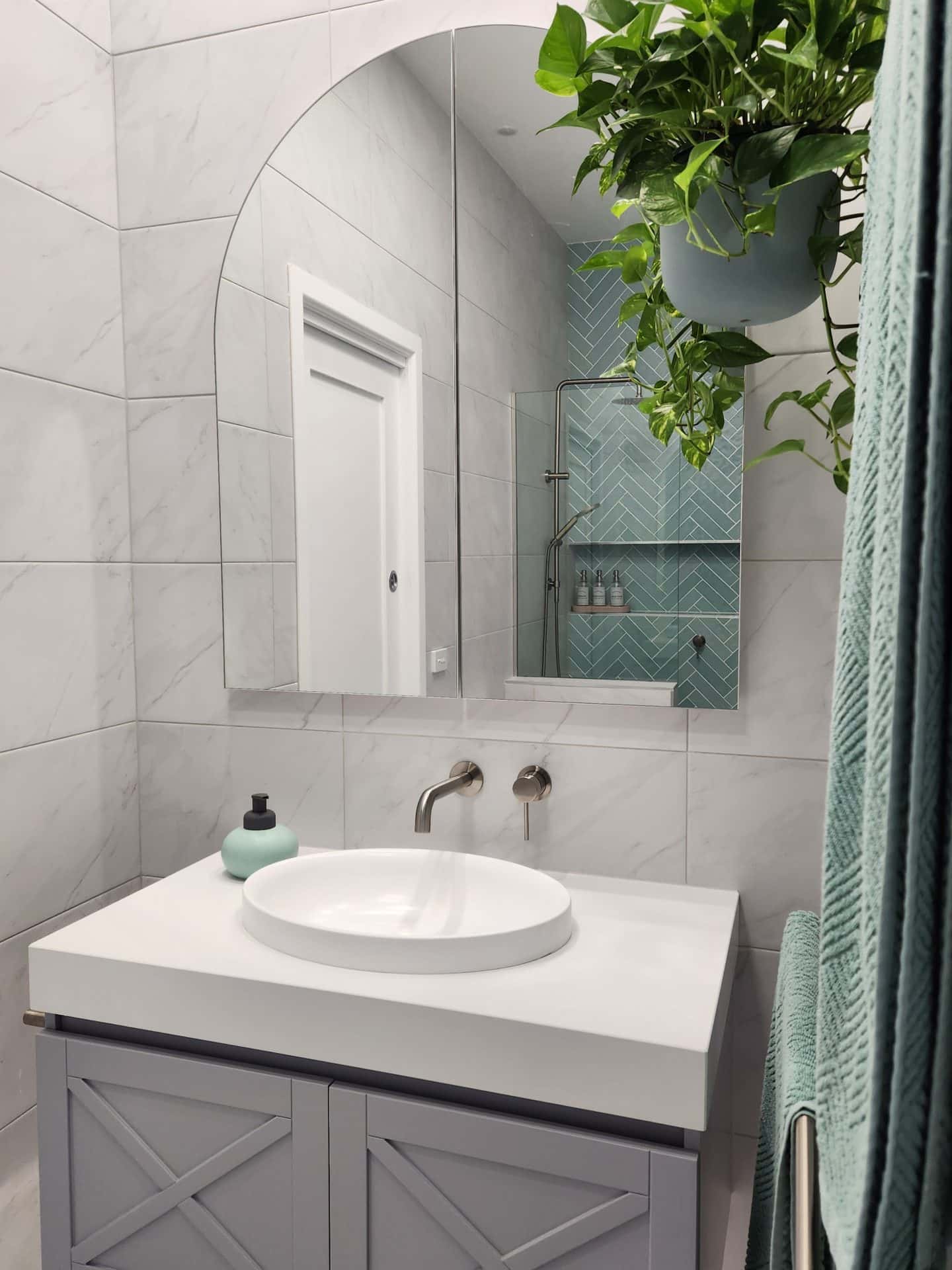 a modern bathroom with a plant hanging on the wall.