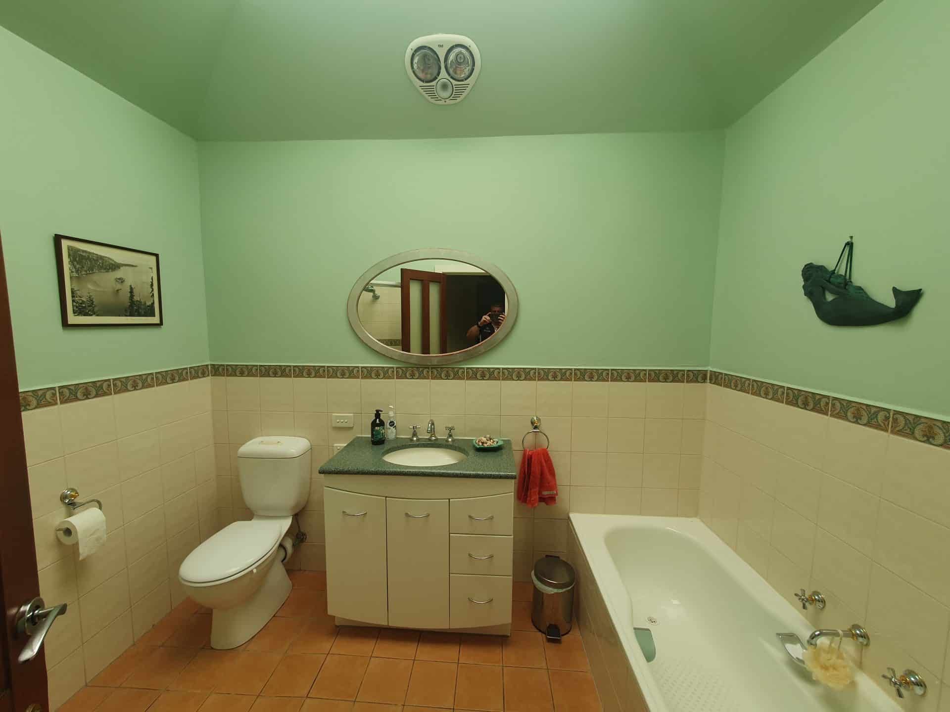 a bathroom with a toilet, sink, and mirror.