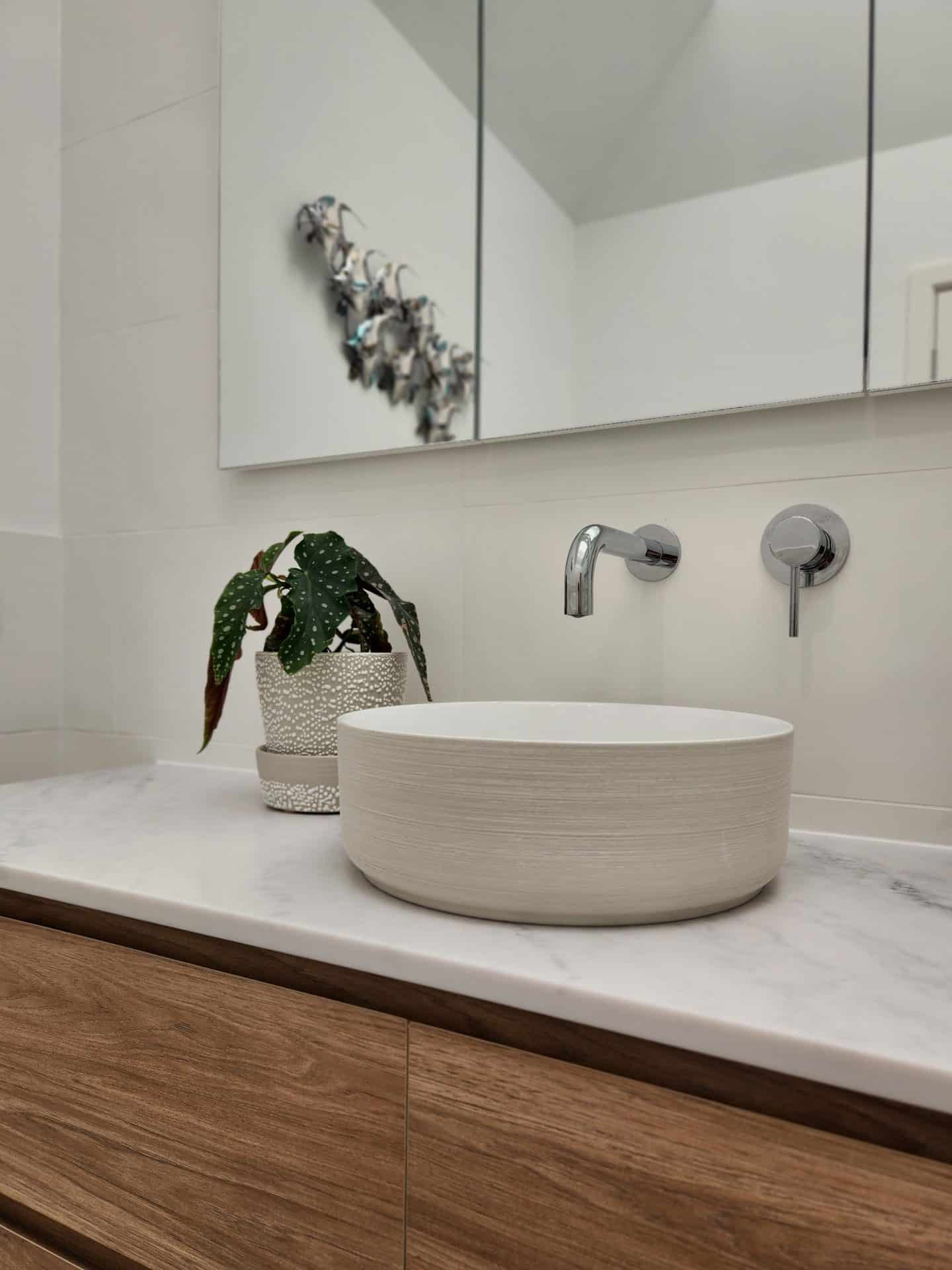 a modern bathroom with a white sink and mirror.