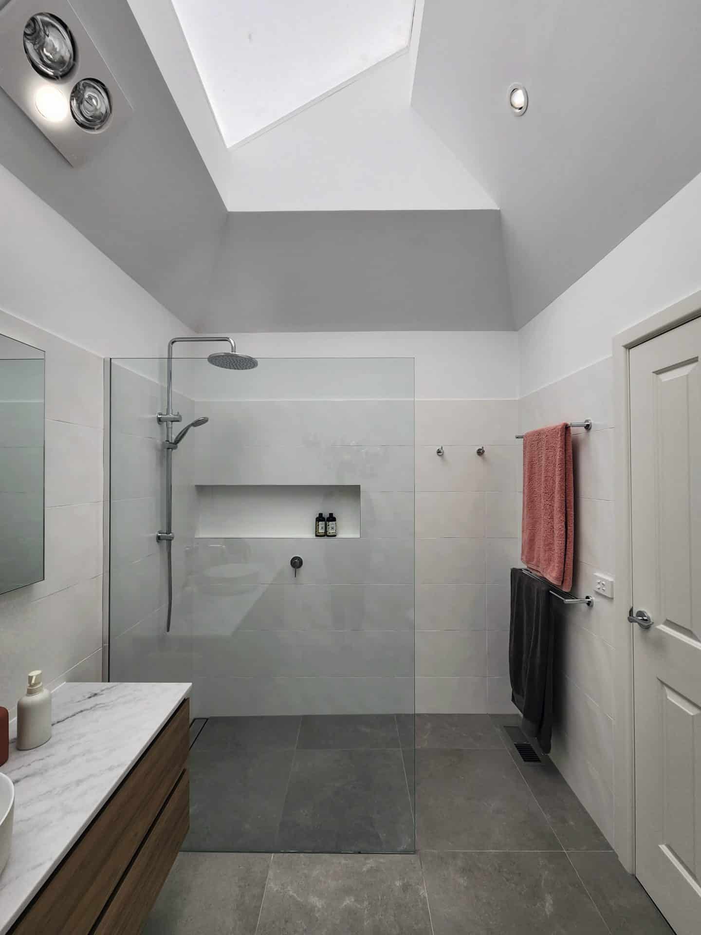 A renovated bathroom with a skylight over the shower.